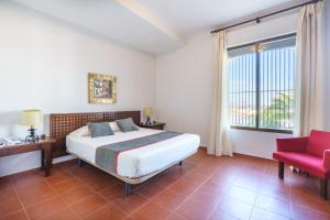 Un dormitorio con una cama y una silla roja. en Venta del Alto Hotel las Cumbres by Vivere Stays, en El Garrobo