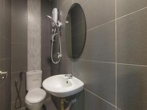 OYO 876 Hotel Sanctuary في بيتالينغ جايا: حمام مع مرحاض ومغسلة ومرآة