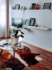 un soggiorno con tavolo in vetro e TV di Bijoux Non-Load-Shedding Self-Catering Apartment in Central Cape Town a Città del Capo