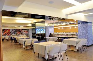 a dining room with white tables and chairs at Fish Hotel Kaohsiung in Kaohsiung