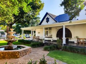 una casa con una fuente en el patio en Bauhenia Guesthouse, en Potchefstroom