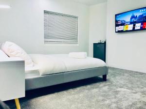 a bedroom with a bed with a tv on the wall at Unique New 4 Bedroom House, HS2, Business People, Contractors & Families in Minworth