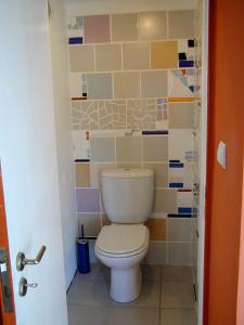 a bathroom with a toilet with colorful tiles at Casa 3 Águias in Aveiro