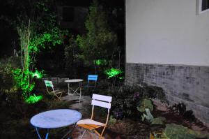 a group of chairs and a table in a garden at night at Kunming Stone Forest Homestay in Kunming