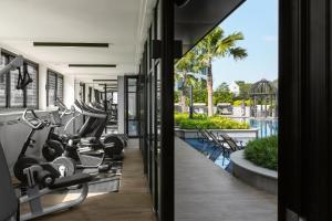 einen Fitnessraum mit Kardiogeräten und einem Pool in der Unterkunft Grand Park City Hall in Singapur