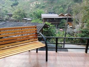 una panca di legno seduta in cima a un balcone di Lungphut Homestay a Chiang Mai