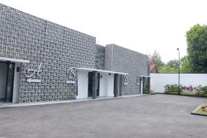 um edifício de tijolos com um parque de estacionamento em frente em RedDoorz Plus near UNIMED Medan em Medan