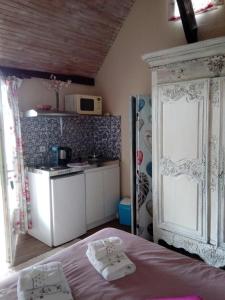 1 dormitorio con 1 cama y cocina con microondas en domaine du mont scolan, en Montgardon