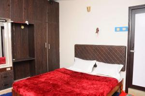 a bedroom with a large bed with a red blanket at Green Woods Homestay in Kodaikānāl +9 photos