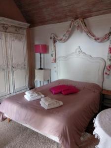 1 dormitorio con 1 cama grande y 2 toallas. en domaine du mont scolan, en Montgardon