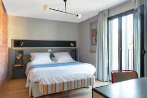 a bedroom with a bed and a desk and a table at Hotel Brummell in Barcelona