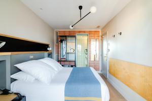 a bedroom with a large bed and a bathroom at Hotel Brummell in Barcelona
