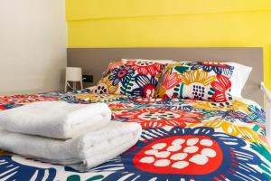 a bed with a colorful blanket and pillows on it at Deco city center apartment in Heraklio
