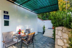 a patio with a table and chairs and a fence at Apartments Lorena Mljet in Pomena