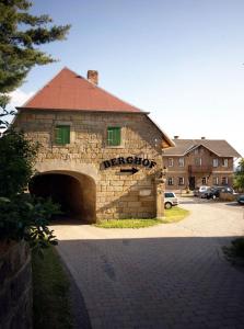 un bâtiment en briques avec un garage muni d'un panneau. dans l'établissement Berghof Lichtenhain, à Lichtenhain