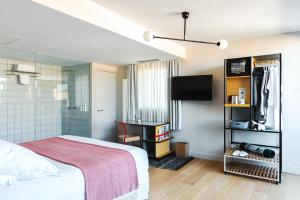 a bedroom with a bed and a tv in a room at Hotel Brummell in Barcelona