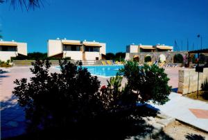 a swimming pool in front of a building at Residence Punta Longa in Favignana