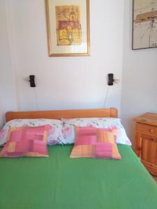Una cama con dos almohadas encima. en Apartments Ivanković en Preko