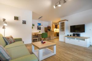 ein Wohnzimmer mit einem Sofa und einem TV in der Unterkunft Ferienwohnungen Alpentraum - Mäusle in Oberstdorf