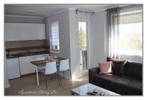 a kitchen and a living room with a couch and a table at Apartment Cherry Lux in Zrenjanin