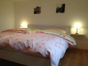 a bedroom with a bed with two lamps on it at Ferienwohnungen Alpentraum - B'm Wolfgangar in Oberstdorf