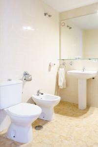 een witte badkamer met een toilet en een wastafel bij Venta del Alto Hotel las Cumbres by Vivere Stays in El Garrobo