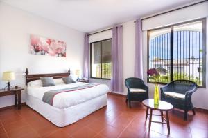 Un dormitorio con una cama y una mesa y sillas. en Venta del Alto Hotel las Cumbres by Vivere Stays, en El Garrobo