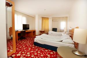 ディヤルバクルにあるDiyarbakır otelのベッドと机があるホテルの部屋