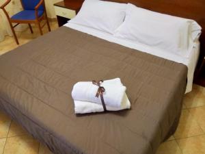 a bed with two white towels on it at Case Vacanze Ancora in Porto Empedocle