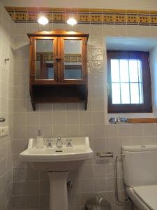 a bathroom with a sink and a toilet and a window at Colores en el Viento in Frigiliana