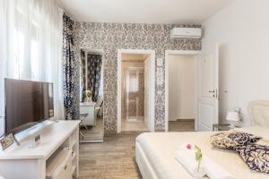 1 dormitorio con cama, TV y baño en Central City Rooms, en Bolonia