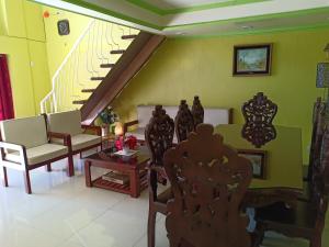 a living room with a staircase and chairs at A.C. Asistin Transient House in Baguio