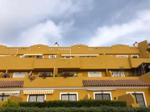 ein gelbes Gebäude mit weißen Fenstern und Pflanzen in der Unterkunft Vera Ciao Naturista in Vera