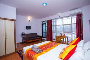 a bedroom with a large bed and a living room at The Boudha Inn in Kathmandu