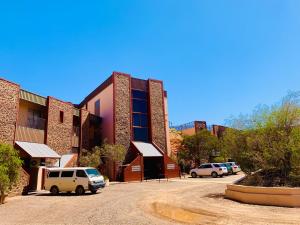 
a car parked in front of a brick building at Desert Cave Hotel in Coober Pedy
