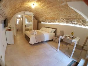 a bedroom with a bed and a table in a room at B&B MONTEBELLO in Trani