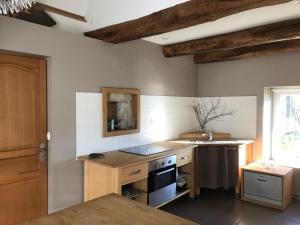 uma cozinha com um lavatório e um fogão forno superior em La petite maison de Marie em Port-sur-Saône