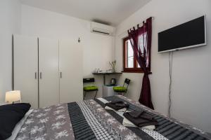Schlafzimmer mit einem Bett und einem Flachbild-TV in der Unterkunft Room Mar in Vis