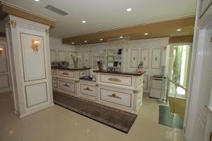 a large kitchen with white cabinets and a counter at Capital Tirana Hotel Bruçi in Tirana