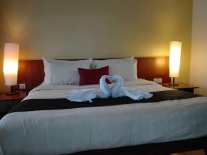 dos cisnes están sentados en la parte superior de una cama en Langkawi Lagoon Hotel Resort en Kampung Padang Masirat