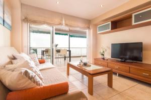 a living room with a couch and a tv at Homes & Go Bell Reco Deluxe I in La Pineda
