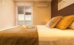 a bedroom with a bed with a cat laying on it at Homes & Go Bell Reco Deluxe I in La Pineda