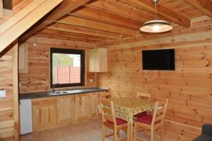 a dining room with a table in a log cabin at Słoneczny Zakątek in Sztutowo