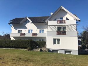 a white building with a black roof at Superior-Apartment mit Pool und Seezugang in Velden am Wörthersee
