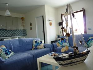 una sala de estar con un sofá azul y un barco sobre una mesa en Casa Tramonto, en Lipari
