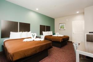 um quarto de hotel com duas camas com toalhas brancas em Express Inn - Spring em Spring