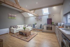 a kitchen and living room with a couch and a table at Little Oak by RentMyHouse in Hereford