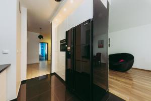 Il comprend une cuisine équipée d'un réfrigérateur noir et d'une chaise noire. dans l'établissement ShortStayPoland Leszczyńska (B14), à Varsovie
