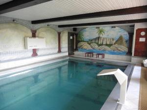 a large swimming pool in a building with a mural at Gasthof _ Pension _ Drei Linden in Pegnitz