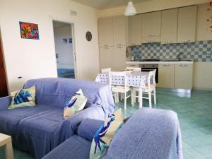 sala de estar con sofá azul y cocina en Casa Tramonto, en Lipari
